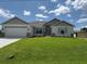 Charming single-story home with a well-manicured lawn and a two-car garage under a cloudy blue sky at 9506 Melody Cir, Port Charlotte, FL 33981