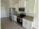 Kitchen featuring white cabinets, stainless steel appliances, granite countertops, and tiled floors at 9506 Melody Cir, Port Charlotte, FL 33981