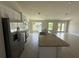 Kitchen featuring a large island with a granite countertop, stainless steel appliances, and an adjacent living area at 9506 Melody Cir, Port Charlotte, FL 33981
