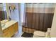 Bathroom with stand alone sink, toilet, tub and shower with framed bamboo mirror at 1108 Ample Ave, Port Charlotte, FL 33948