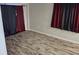 Well-lit bedroom with wood look floors, red curtains, and grey walls at 1108 Ample Ave, Port Charlotte, FL 33948