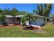 Well-kept home with a manicured lawn, palm trees, and neat landscaping at 1108 Ample Ave, Port Charlotte, FL 33948
