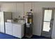 Garage with blue floors, laundry machines, and water heater setup at 1108 Ample Ave, Port Charlotte, FL 33948