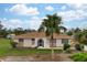 Single-story house with a palm tree and well-maintained lawn at 1713 Belvidere Rd, Englewood, FL 34223