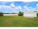 Detached garage with a grassy yard and white fence at 1713 Belvidere Rd, Englewood, FL 34223