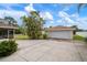 Single car garage with a paved driveway and tropical landscaping at 1713 Belvidere Rd, Englewood, FL 34223