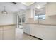Bright kitchen features white cabinets, tile flooring, and a view to the backyard at 1713 Belvidere Rd, Englewood, FL 34223