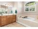 Bathroom with a soaking tub, double vanity, and tile flooring at 18138 Petoskey Cir, Port Charlotte, FL 33948