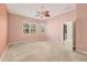 Spacious bedroom with neutral walls, ceiling fan, and door to bathroom at 1916 Nottingham Trl, Punta Gorda, FL 33980