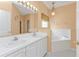 Bathroom with a double vanity, bathtub and shower at 24088 Buckingham Way, Punta Gorda, FL 33980