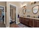 Double vanity bathroom with dark brown cabinets and a large mirror at 26081 Templar Ln, Punta Gorda, FL 33983