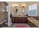 Bathroom with a large soaking tub, double vanity, and window at 26081 Templar Ln, Punta Gorda, FL 33983