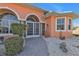 Arched entryway with double screened doors, surrounded by well maintained shrubs at 26081 Templar Ln, Punta Gorda, FL 33983
