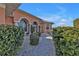 Welcoming walkway to an arched entryway with lush landscaping at 26081 Templar Ln, Punta Gorda, FL 33983