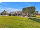 Landscaped yard with lush grass and mature trees in front of a charming home at 26081 Templar Ln, Punta Gorda, FL 33983