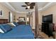 Main bedroom with a large four-poster bed, TV, and ceiling fan at 26081 Templar Ln, Punta Gorda, FL 33983
