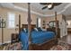 Spacious main bedroom with a large, ornate four-poster bed and ceiling fan at 26081 Templar Ln, Punta Gorda, FL 33983