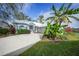 White house with blue accents, landscaping, and a large driveway at 3116 Silkwood Ln, Port Charlotte, FL 33953