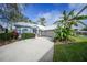 White house with blue accents, landscaping, and a two-car garage at 3116 Silkwood Ln, Port Charlotte, FL 33953