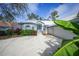 Front view of a white house with blue trim and lush landscaping at 3116 Silkwood Ln, Port Charlotte, FL 33953