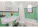 Bathroom with mint green tile and pedestal sink at 330 45Th S St, St Petersburg, FL 33711