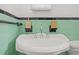 Bathroom with mint green tile and pedestal sink at 330 45Th S St, St Petersburg, FL 33711