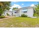 Lovely house with white brick, blue awnings, and a manicured front lawn on a sunny day at 330 45Th S St, St Petersburg, FL 33711