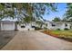 White brick house with black and white awnings, a large driveway, and a well-manicured lawn at 330 45Th S St, St Petersburg, FL 33711