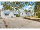 White house with blue awnings, landscaped yard, and brick driveway at 330 45Th S St, St Petersburg, FL 33711
