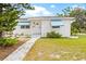 Charming home featuring a well-maintained lawn, blue awnings, and a paved walkway at 330 45Th S St, St Petersburg, FL 33711