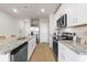 Modern kitchen with white cabinets, granite countertops, and stainless steel appliances at 44197 Frontier Dr, Punta Gorda, FL 33982