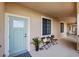 Condo entry with light teal door and small patio seating at 900 E Marion Ave # 1403, Punta Gorda, FL 33950
