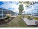 Enjoy backyard views of lush landscaping, a screened-in pool, canal, and mature palm trees at 115 Leland Se St, Port Charlotte, FL 33952