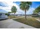 Enjoy backyard views of lush landscaping, grassy areas, canal, and mature palm trees at 115 Leland Se St, Port Charlotte, FL 33952