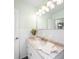 Bathroom featuring a white vanity with stone countertop, white tiling and decorative lighting at 115 Leland Se St, Port Charlotte, FL 33952
