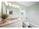 Bright, white bathroom featuring a vanity with granite countertop and shower-tub combination at 115 Leland Se St, Port Charlotte, FL 33952