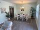 Charming dining area featuring a wooden table, white chairs, and stainless steel refrigerator in a cozy setting at 115 Leland Se St, Port Charlotte, FL 33952