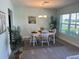 Bright dining area with a wooden table, white chairs, and ample natural light from the large window at 115 Leland Se St, Port Charlotte, FL 33952