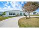 Single story home with light teal exterior, circular driveway, and a manicured lawn at 115 Leland Se St, Port Charlotte, FL 33952