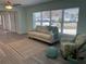 Comfortable living room with neutral sofa, accent chair, and area rug, bathed in natural light from a large window at 115 Leland Se St, Port Charlotte, FL 33952