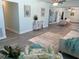 Spacious living area with light gray flooring and neutral furniture, connecting seamlessly to dining and outdoor spaces at 115 Leland Se St, Port Charlotte, FL 33952