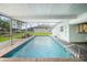 Relax in this screened pool with brick pavers, clear blue water, and canal views at 115 Leland Se St, Port Charlotte, FL 33952