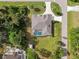 An aerial view of a house with a pool and a large backyard, surrounded by trees at 1160 Rizzo St, Port Charlotte, FL 33952