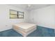 Bright bedroom with blue carpet, a queen-size bed, and a window with blinds at 1160 Rizzo St, Port Charlotte, FL 33952