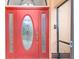 Inviting red front door with glass accents and sidelights at 1160 Rizzo St, Port Charlotte, FL 33952