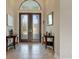 Bright foyer with double doors, tile floor, and two half-moon tables at 1228 Eppinger Dr, Port Charlotte, FL 33953