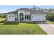 Single-story home with a light green exterior, tile roof, and paved driveway at 1228 Eppinger Dr, Port Charlotte, FL 33953