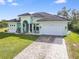 One-story house with a light green exterior, tile roof, and a paved driveway at 1228 Eppinger Dr, Port Charlotte, FL 33953
