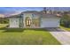 Light green single-story house with tile roof, a fountain, and a two-car garage at 1228 Eppinger Dr, Port Charlotte, FL 33953
