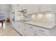 Modern kitchen features white cabinets, granite countertops and a tile backsplash at 1228 Eppinger Dr, Port Charlotte, FL 33953